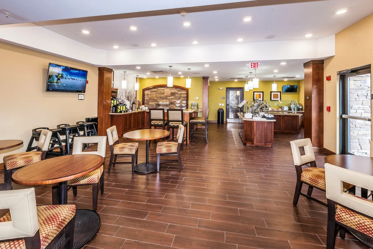 A comfortable living and dining space featuring a wooden counter with seating, a cozy spot to enjoy meals or conversation. A television is prominently displayed, hinting at relaxing evenings spent watching movies or catching up on favorite shows. Soft lighting and homey decor create an inviting area for unwinding and socializing.